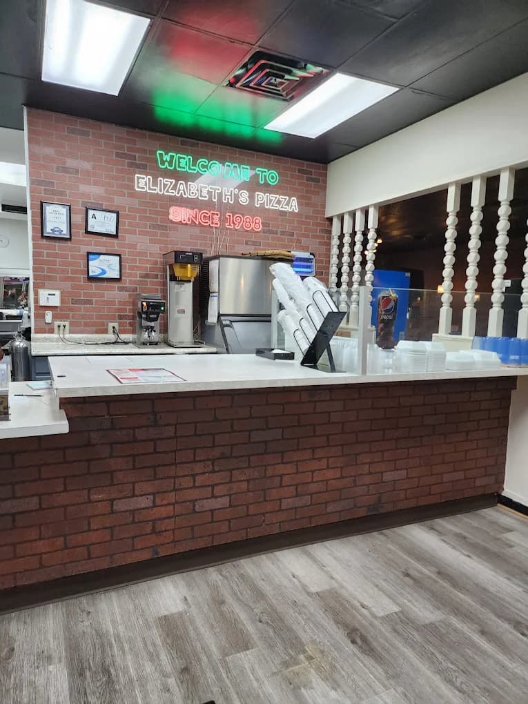 The brick service counter and Since 1988 welcome sign at Elizabeth’s Pizza