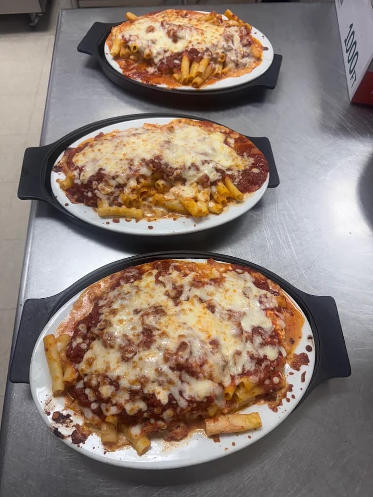 Three plates of baked pasta topped with tomato sauce and melted cheese