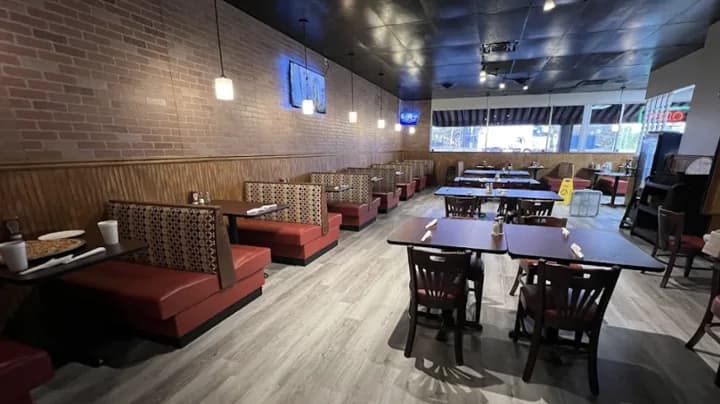 Tables and booths in the brick-lined dining room at Elizabeth’s Pizza